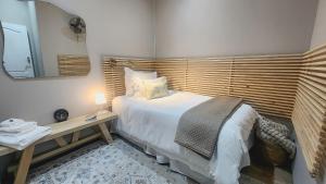 1 dormitorio con cama y mesa con espejo en Hanepoot 503, en Paarl