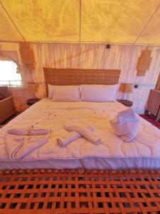 ein großes weißes Bett mit zwei Personen auf dem Bett in der Unterkunft Mhamid Luxury Camp in Mhamid