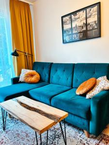 un divano blu in soggiorno con tavolino di Apartament Curie a Tychy