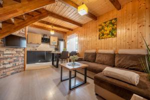 a living room with a couch and a table at Domki SUNSET Bałtycka in Dąbki