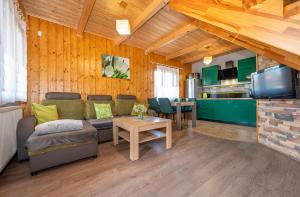ein Wohnzimmer mit einem Sofa und einem Tisch in der Unterkunft Domki SUNSET Bałtycka in Dąbki