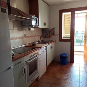 a kitchen with a sink and a stove top oven at La Colina Playa&Golf in Huelva