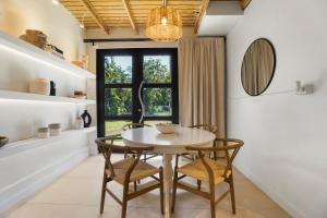 a dining room with a table and chairs and a window at Villa Costera Joyuda in Cabo Rojo