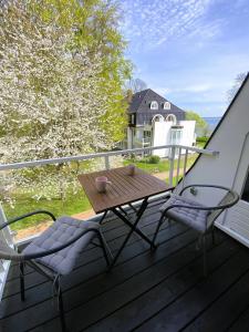 einen Holztisch und zwei Stühle auf einer Terrasse in der Unterkunft Strandappartment Meerkieker in Travemünde