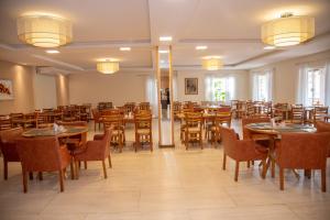 a dining room filled with tables and chairs at Pousada do Lago Penedo in Penedo