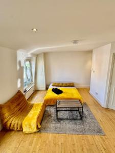 a bedroom with a bed with a yellow blanket and a table at Victoria - 1 bedroom appartment 4 people in London