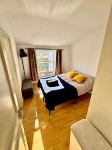 a bedroom with a bed with yellow pillows and a window at Victoria - 1 bedroom appartment 4 people in London