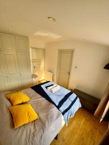 a bedroom with a bed with yellow and blue pillows at Victoria - 1 bedroom appartment 4 people in London