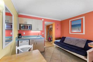 Pelican Point on Clearwater Beach في كليرووتر بيتش: مطبخ وغرفة معيشة مع أريكة في غرفة