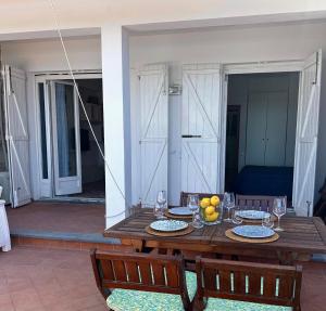 a wooden table with a bowl of fruit on a patio at Raffaela's House - (San Montano) in Massa Lubrense +29 photos
