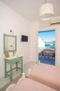 a bedroom with two beds and a table with a mirror at A2- Alexandri Apartment in Nydri