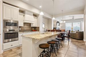 une cuisine avec des placards blancs et un grand îlot avec des tabourets de bar dans l'établissement Zion's Edge townhouse, à Washington 38 autres photos