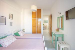 a bedroom with two beds and a table and a sink at A2- Alexandri Apartment in Nydri