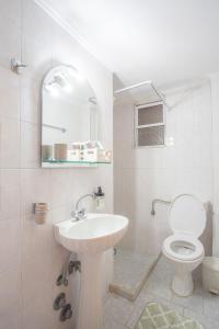 a white bathroom with a toilet and a sink at A2- Alexandri Apartment in Nydri +25 photos