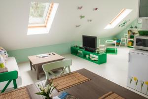 a living room with a tv and a table at Pension Traumfänger in Friedland