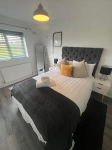 een slaapkamer met een groot bed met een groot hoofdeinde bij Serene Escape in Monmore Green