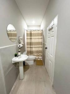 ein Badezimmer mit einem WC, einem Waschbecken und einem Spiegel in der Unterkunft Endless Summer in El Zapote