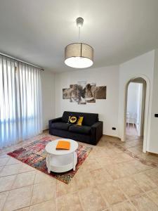 a living room with a black couch and a table at LA Home - Animal House in Viareggio