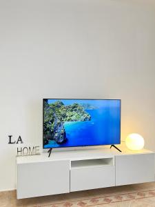 a living room with a large television on a white cabinet at LA Home - Animal House in Viareggio +31 photos