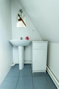 een witte badkamer met een wastafel en een spiegel bij L'échappée belle in Fontenay