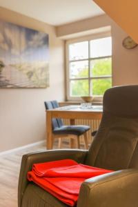 a red shirt sitting on a chair in a room at Arche Svea Kiebitz in Spiekeroog