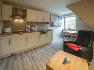 a kitchen with a couch and a chair and a table at Arche Svea Kiebitz in Spiekeroog