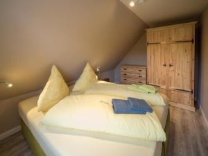 a bedroom with a large white bed in a attic at Arche Svea Kiebitz in Spiekeroog