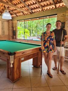 a man and a woman standing next to a pool table at Sitio Bonanza in Guaratuba