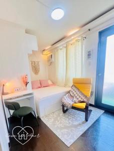 a small room with a bed and a desk and a chair at Casa con Amor - Dreamy Pastel Boho-Chic Haven in Manila