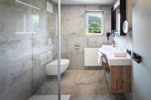 a bathroom with a toilet and a sink and a shower at Hotel Gasthof Siggen in Neukirchen am Großvenediger