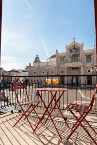 dos sillas y una mesa frente a un edificio en Duomo Rooms - Manfredi Homes&Villas, en Manfredonia