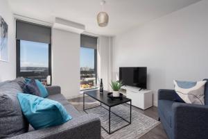 a living room with a couch and a table with a tv at Pass the Keys Liverpool Baltic Triangle Spacious Flat Sleeps 4 in Liverpool