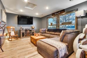 uma sala de estar com um sofá e uma televisão em Stylish Lakefront Cabin in Zimmerman with Hot Tub! 
