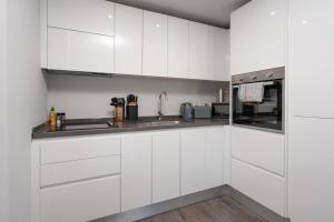 a white kitchen with white cabinets and a sink at Pass the Keys Liverpool Baltic Triangle Spacious Flat Sleeps 4 in Liverpool