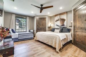 um quarto com uma cama e uma ventoinha de tecto em Stylish Lakefront Cabin in Zimmerman with Hot Tub! 
