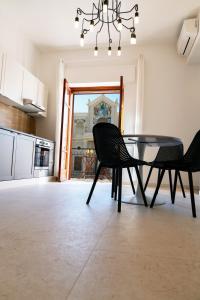 comedor con mesa y sillas en la cocina en Duomo Rooms - Manfredi Homes&Villas, en Manfredonia