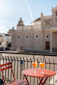una mesa roja con dos bebidas delante de un edificio en Duomo Rooms - Manfredi Homes&Villas, en Manfredonia