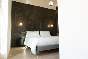 1 dormitorio con cama blanca y pared negra en Duomo Rooms - Manfredi Homes&Villas, en Manfredonia