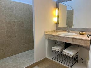La salle de bains est pourvue d'un lavabo et d'une douche. dans l'établissement Hotel L'Oliveraie Jnane Zitoune, à Marrakech
