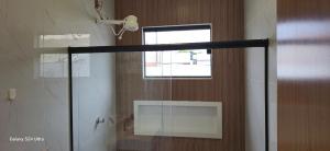 a shower with a glass door in a bathroom at Casa Temporada Sereia do Mar in São Mateus +28 photos