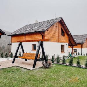 una casa di legno con una panchina di fronte di Ďumbierky Chata 5ka a Mýto pod Ďumbierom