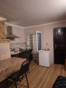 a living room with a kitchen and a table and a refrigerator at Lux-2-or-1- persons Irodion Edoshvili Street #15 in Kutaisi