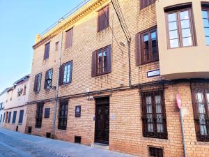 a brick building with windows on a street at Casa Rístori Calicanto in Manzanares