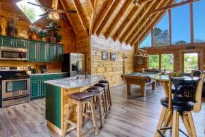 a kitchen with green cabinets and bar stools at City View Chalet in Gatlinburg