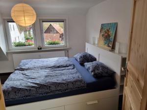 a bedroom with a bed and two windows at Stadt-Ferienwohnung mit 55 m² für 2 erw. Personen und Kind bis 3 Jahren in Bad Lauterberg
