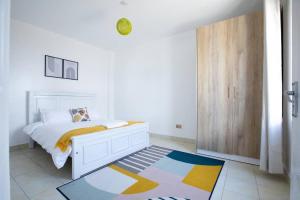 a bedroom with a white bed and a wooden door at Cosy Nest cribs Nairobi in Nairobi
