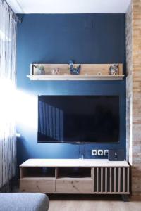 a living room with a flat screen tv on a blue wall at Apartment Tori in Zadar