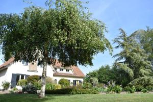 una casa blanca con un árbol en el patio en Le Vrai Paradis en Estréboeuf