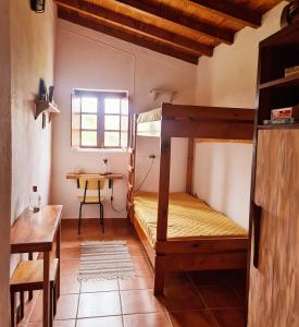 a room with two bunk beds and a table at Casa do Avô António in Bensafrim