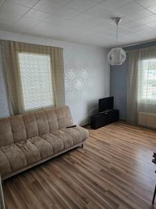 a living room with a couch and a flat screen tv at Majoitus Kulma in Ilomantsi